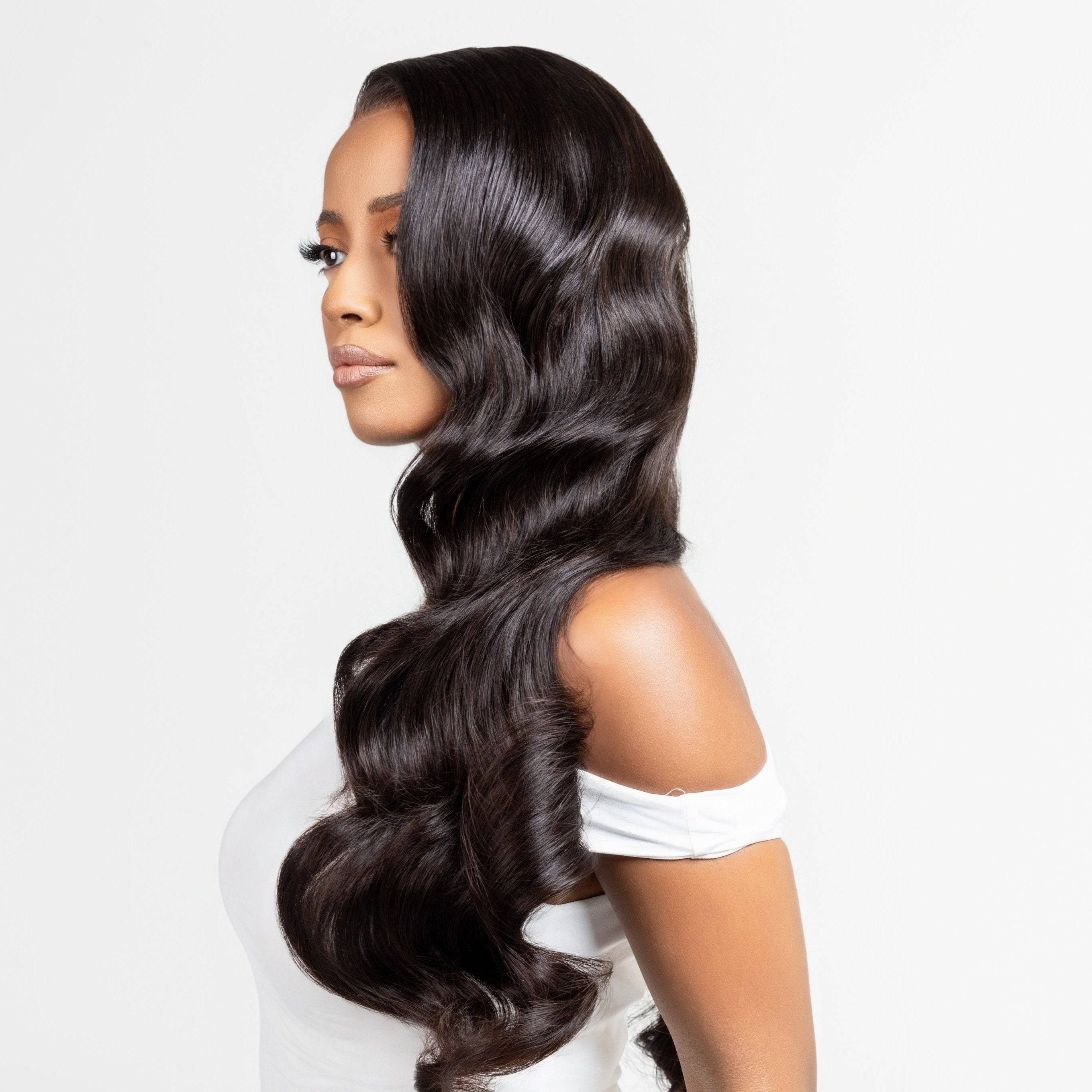 "Model wearing a natural black wig with Hollywood waves, designed for alopecia, hair loss, fashion, or religious reasons. The wig features elegant, flowing curls and is styled against a white studio backdrop. The model&