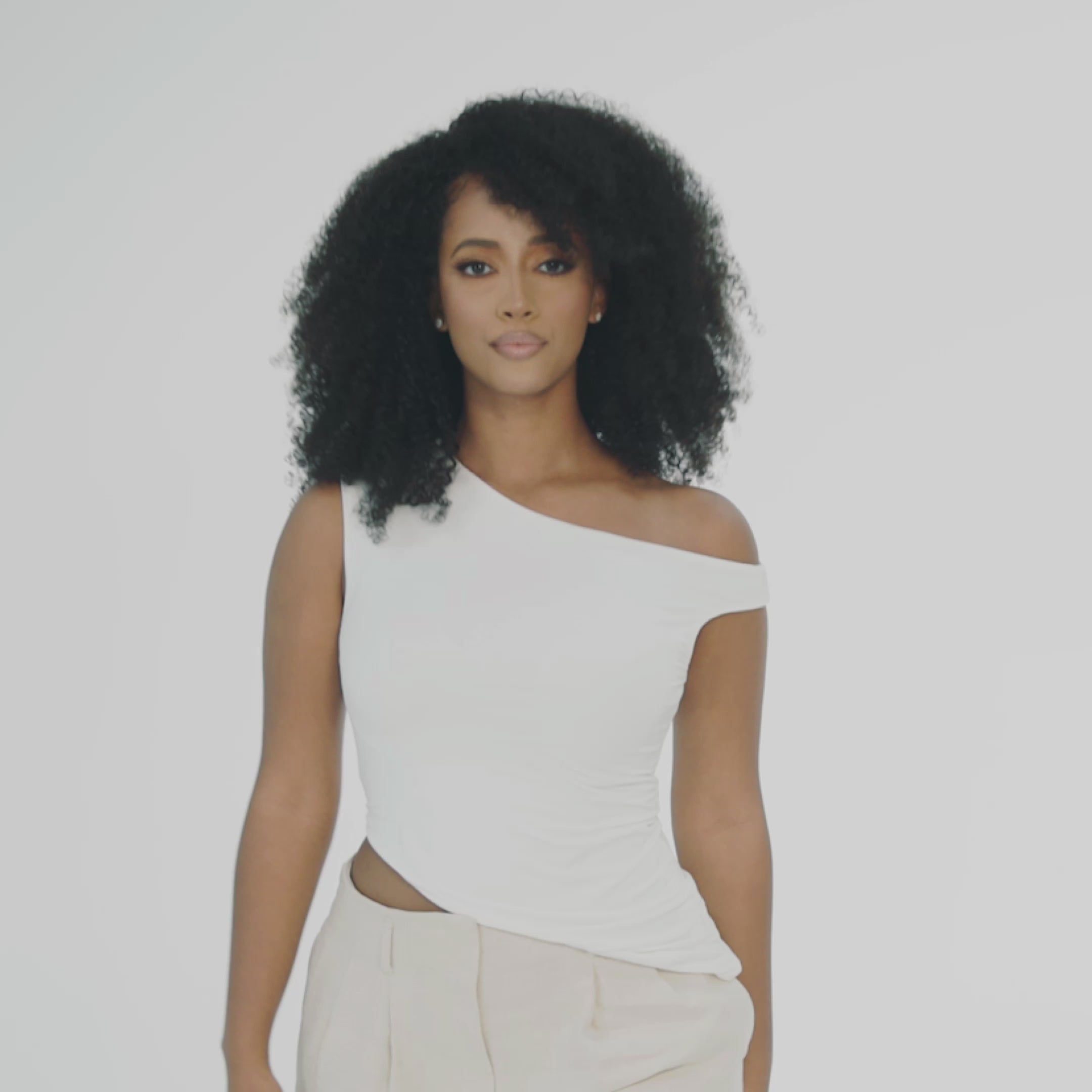 &quot;Model wearing a  afro or kinky texture wig with a side part. This wig is designed for alopecia, hair loss, fashion, or religious reasons. The wig features voluminous, bouncy curls and is showcased against a white studio background. The model has a natural, soft glam makeup look.